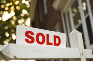 Picture of a sold sign in front of a house.