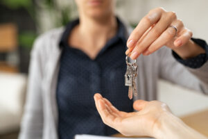 Picture of a woman handing a set of keys to someone.