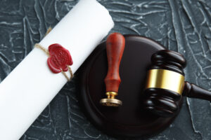 Picture of a sealed will next to a stamp and a gavel.