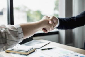 Picture of two people shaking hands in an office.