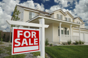 Picture of a house with a For Sale sign outside.