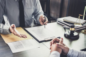 Picture of an attorney speaking to a client across a desk.