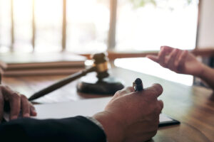 Picture of an attorney and a client speaking to each other across a desk.