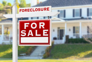 Picture of a foreclosure sale sign outside a white house.