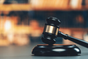 Picture of a gavel sitting on a table with a blurred background.