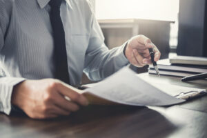 Picture of an estate planning attorney reviewing a document at his desk.